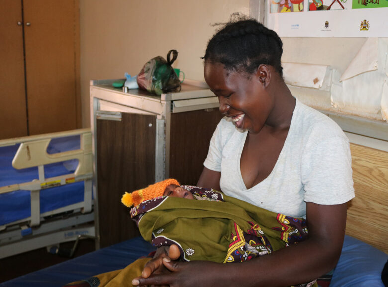 A new mother holds her baby at Kasese Health Center