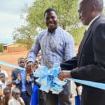Two men cut the ribbon at the opening of the Kabuluzi Primary School in Kabuluzi, Dowa, Malaiw.