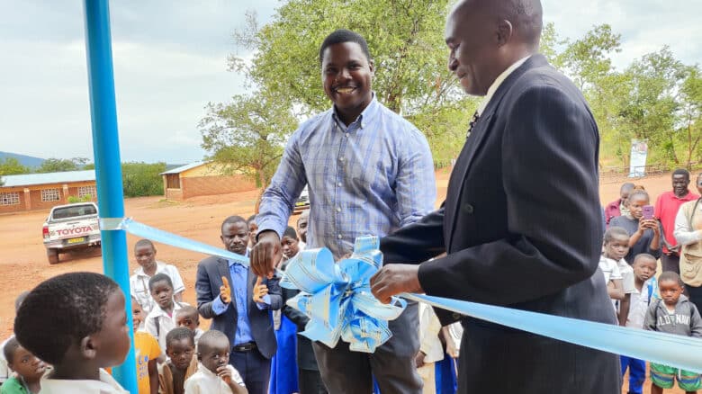 Two men cut the ribbon at the opening of the Kabuluzi Primary School in Kabuluzi, Dowa, Malaiw.