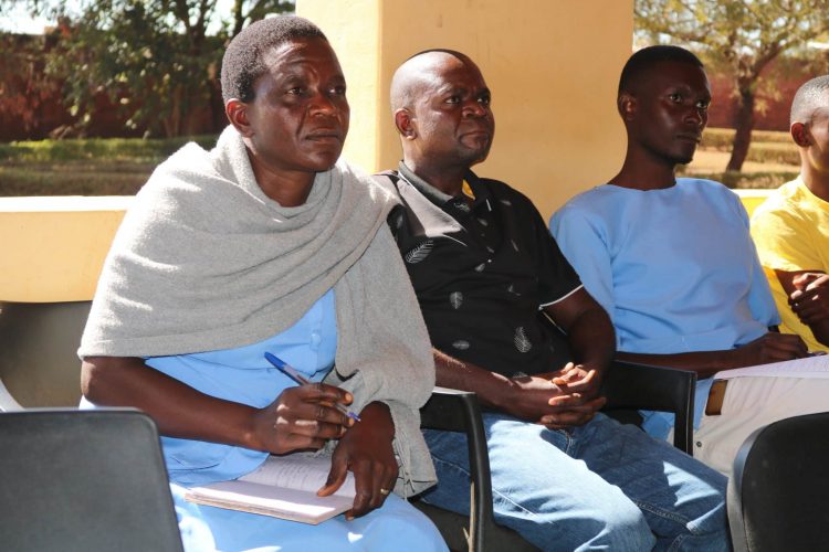 Three people sitting in chairs looking to a speaker who is not pictured