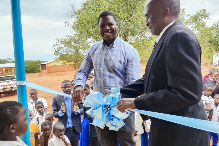 Two men cut the ribbon at the opening of the Kabuluzi Primary School in Kabuluzi, Dowa, Malaiw.